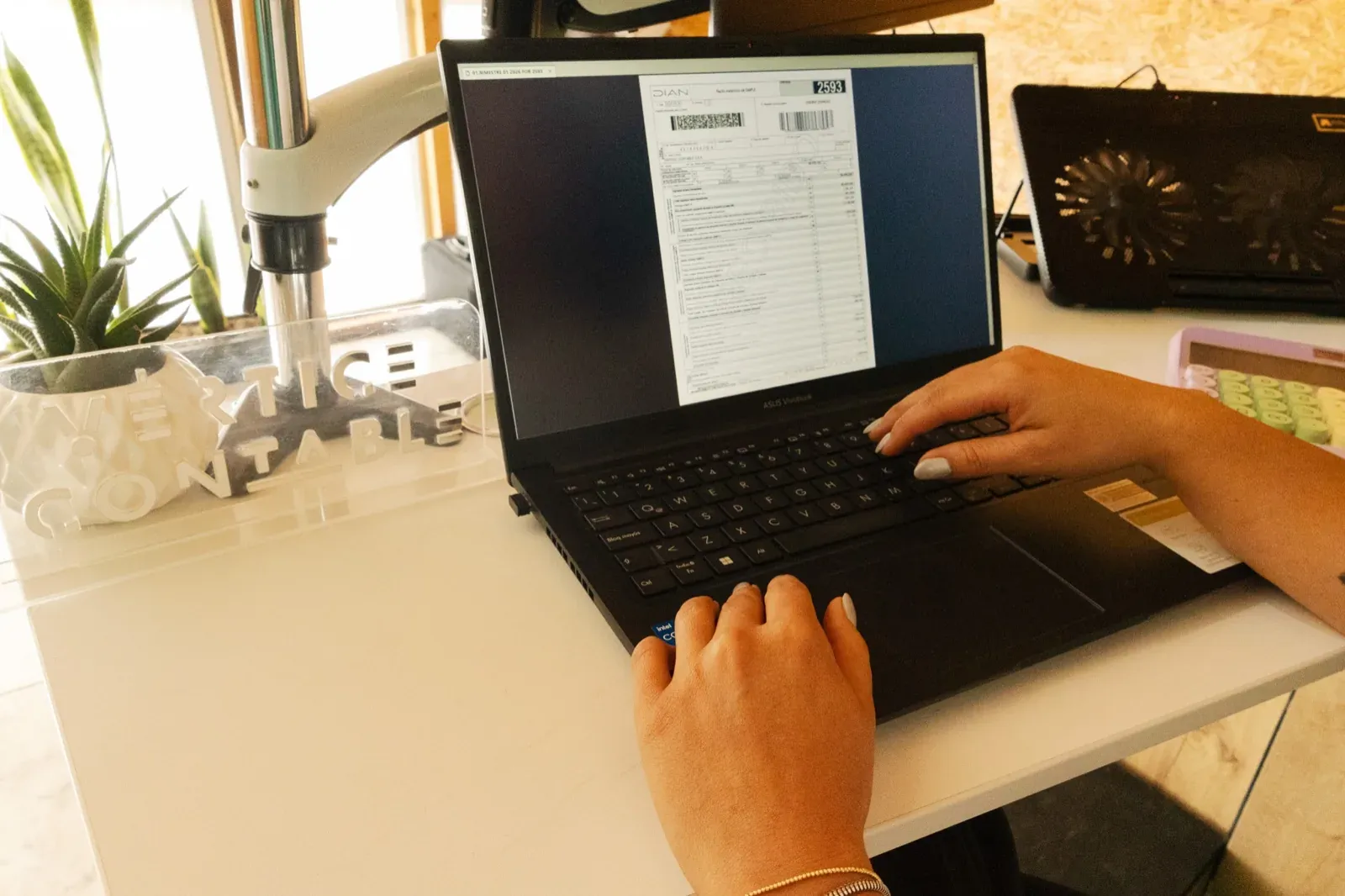 Revisión de un documento soporte en el computador de la oficina de Vértice Contable