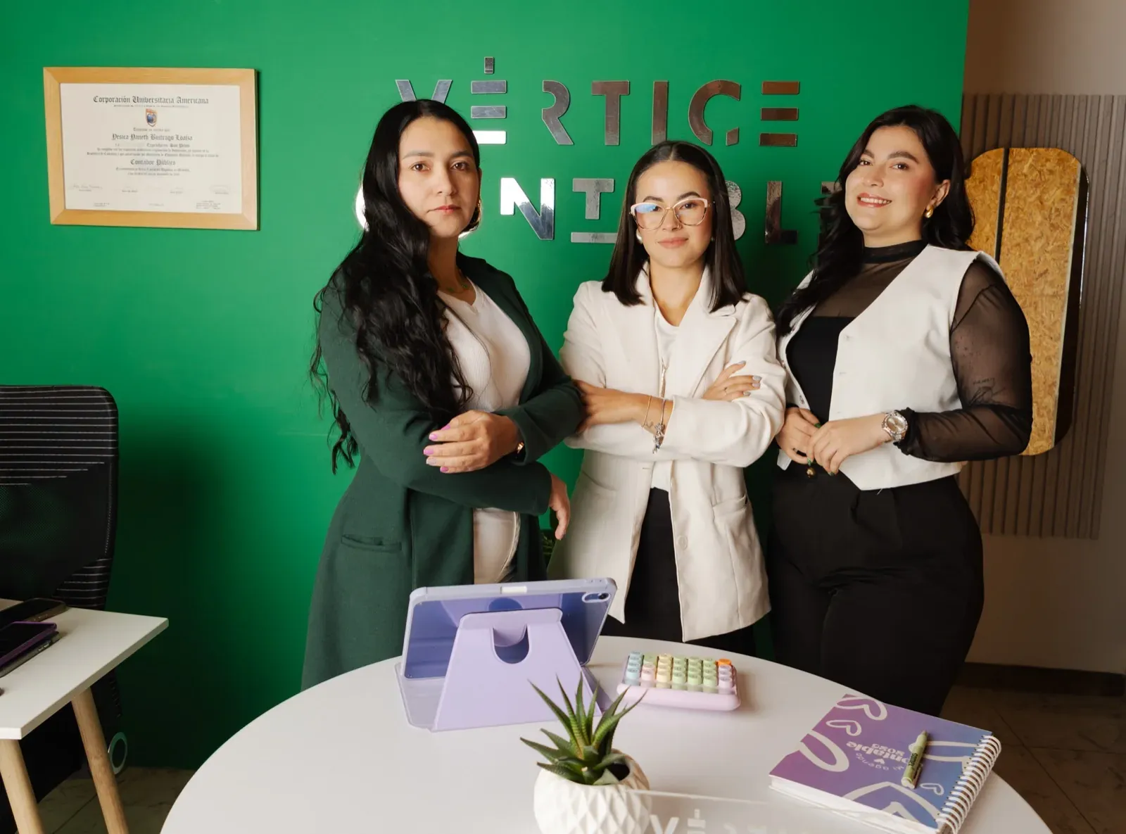 Equipo de Vértice Contable junto a la mesa de trabajo de la oficina