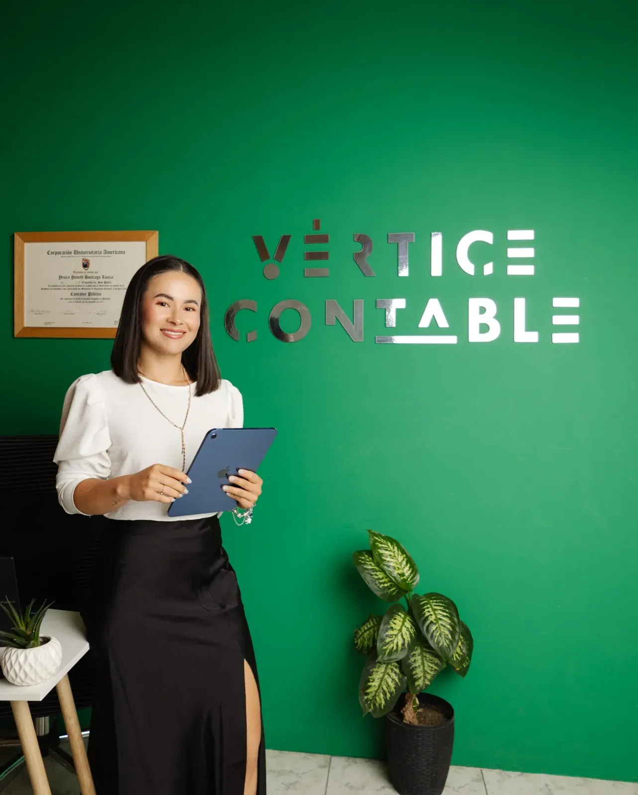 Yesica Buitrago, Socia Directora de Vértice Contable, con una tableta en la oficina